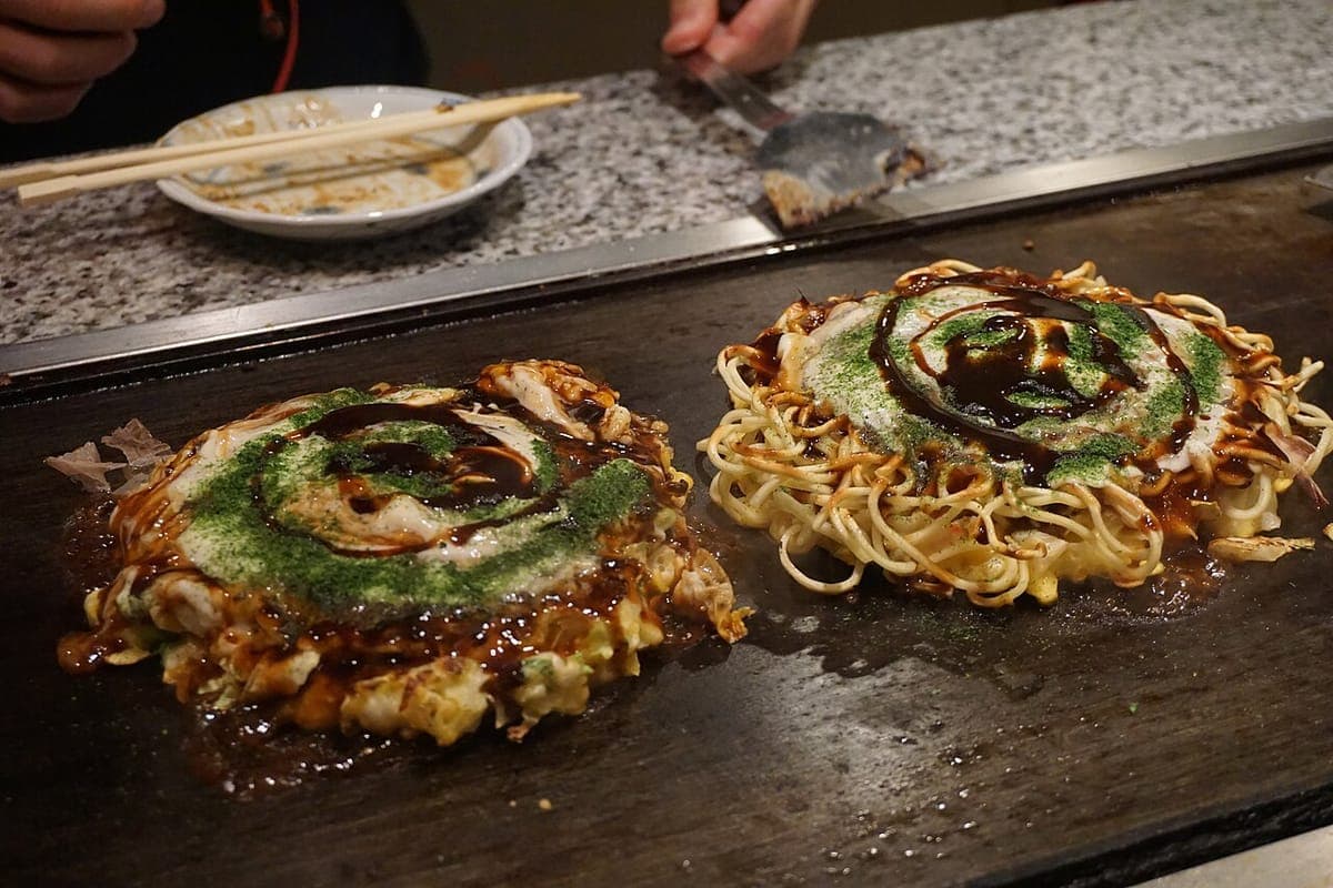 Food cooking on a large flat steel teppan griddle