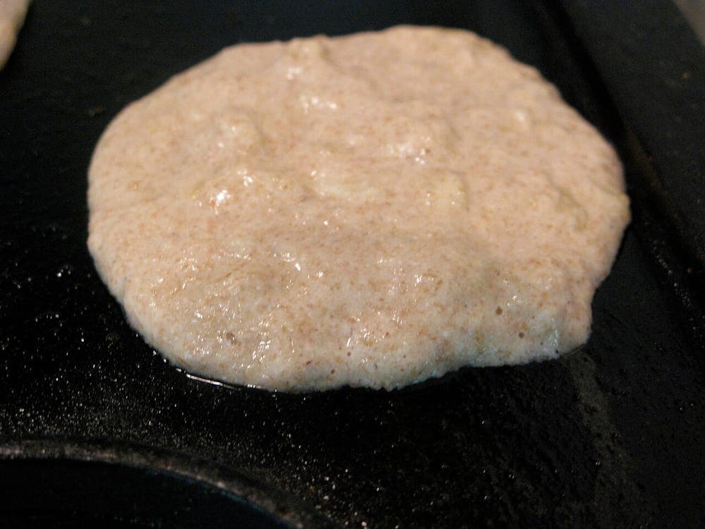 Banana pancakes cooking on a griddle