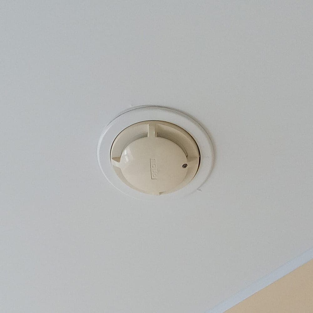 A smoke detector mounted on a ceiling