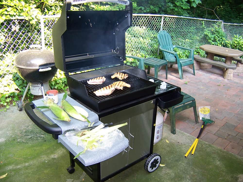 Someone cooking outdoors at a backyard barbecue
