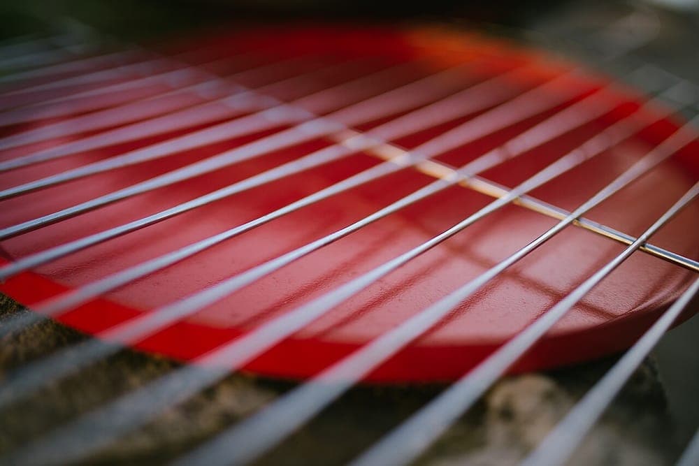 A red grill with metal cooking grates