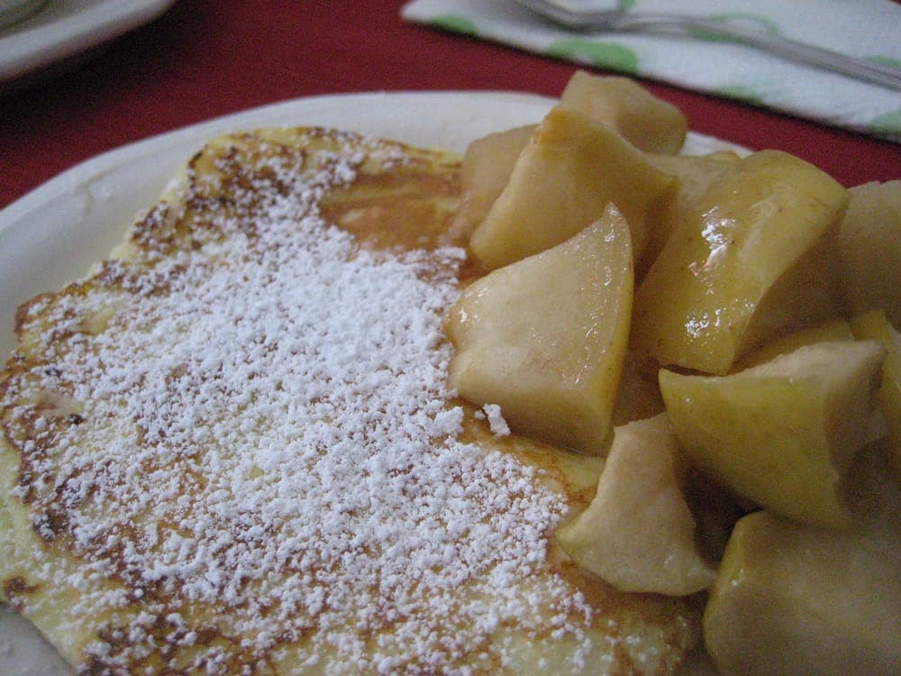 Pancakes cooked on a flat surface, plated with roasted apples