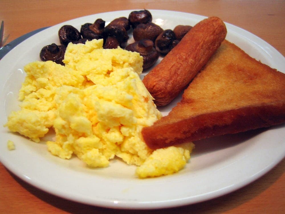 Eggs, sausage, mushrooms and fried bread cooking together
